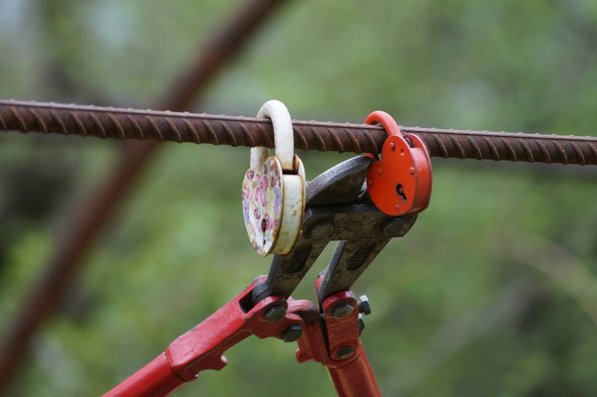 Close-up of an electric wire cutter tool cleanly severing copper electrical wire with insulated handle visible